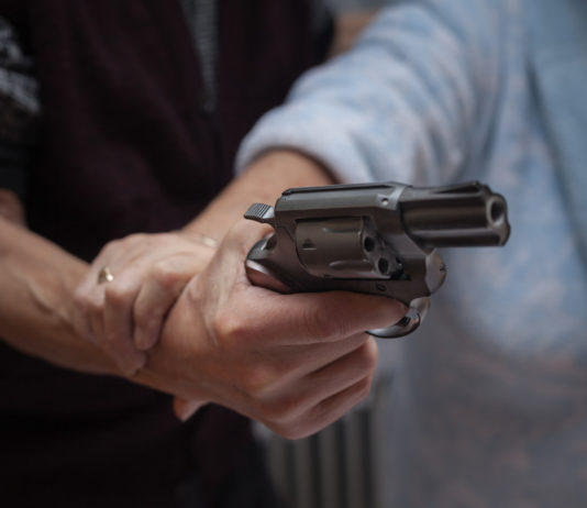 Morde agente e cerca di sottrargli l’arma di ordinanza