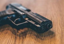 Recepimento della Direttiva armi: dalla Camera parere favorevole con osservazioni pistola in uso alla polizia tedesca su tavolo di legno