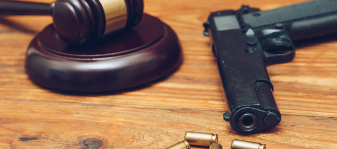 martello del giudice con pistola e proiettili martello del giudice con pistola e quatto proiettili su tavolo di legno: botta e risposta Salvini - Anm sulla riforma della legittima difesa