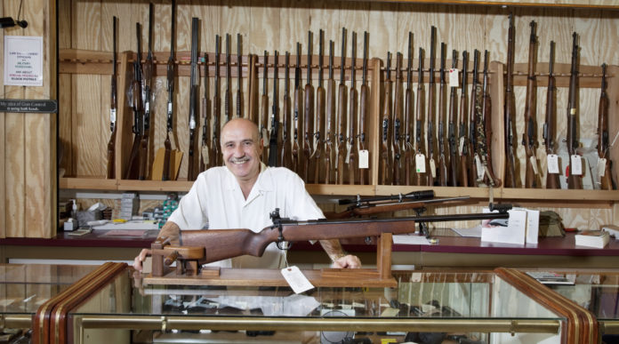 Il mercato delle armi in America prosegue il boom mercato delle armi in America: armiere presenta fucile all'interno di un gunshop americano