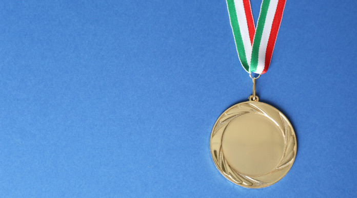 Campionati italiani di tiro a segno ecco i vincitori Campionati italiani di tiro a segno: medaglia d'oro con bandiera italiana, fondo azzurro