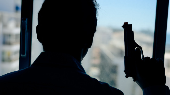 Licenza per uso sportivo e difesa personale la sentenza Licenza per uso sportivo e difesa personale: uomo davanti alla finestra, di spalle, con pistola in mano