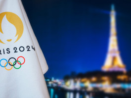 Carte olimpiche per le specialità di tiro: il riepilogo a fine 2022 Carte olimpiche per le specialità di tiro: bandiera Parigi 2024 davanti alla Torre Eiffel di notte