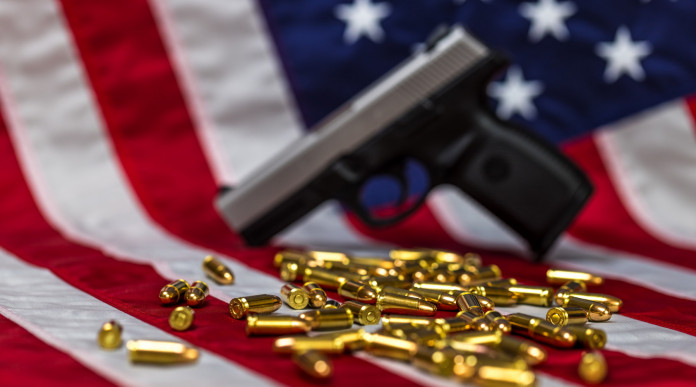 Mercato delle armi in America la situazione a metà novembre Mercato delle armi in America: pistola e proiettili davanti a bandiera americana