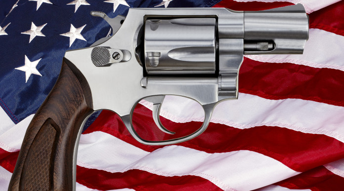 Mercato delle armi in America la situazione a inizio dicembre Mercato delle armi in America: revolver davanti a bandiera americana