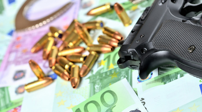 Valore economico del settore armiero in Italia lo studio Valore economico del settore armiero in Italia: pistola con munizioni e banconote in euro
