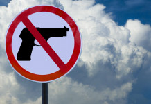 Quanto dura la preclusione alla detenzione di armi? Quanto dura la preclusione alla detenzione di armi: cartello con segnale di pistola vietata, davanti a cielo con nuvole