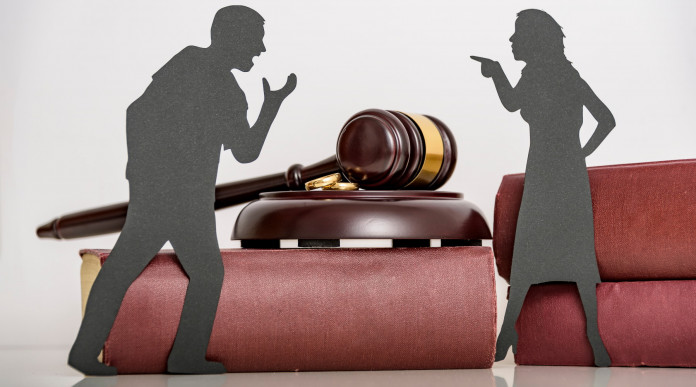 Separazione coniugale e detenzione di armi: la sentenza Separazione coniugale e detenzione di armi: coppia stilizzata discute vicino a martello del giudice