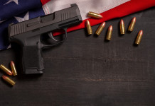 Come sta andando il mercato delle armi in America? Come sta andando il mercato delle armi in America? pistola e munizioni su bandiera americana