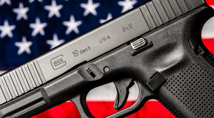 Quanti background check richiesti in America nel 2025 Quanti background check richiesti in America nel 2025 - pistola glock g19 gen 5 davanti a bandiera americana, stelle e strisce
