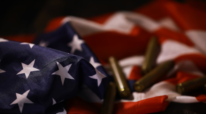 Quanti background check richiesti in America nei primi otto mesi del 2026 - bossoli su bandiera americana